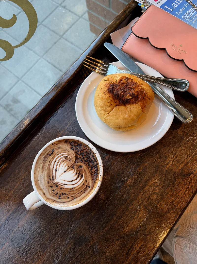 Coffee and a round baked pastry on the window counter
